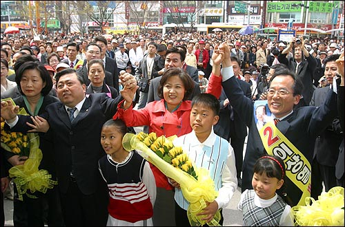 추 선대위장이 김홍일 의원과 이상열 후보의 손을 치켜들며 시민들의 박수에 답하고 있다. 